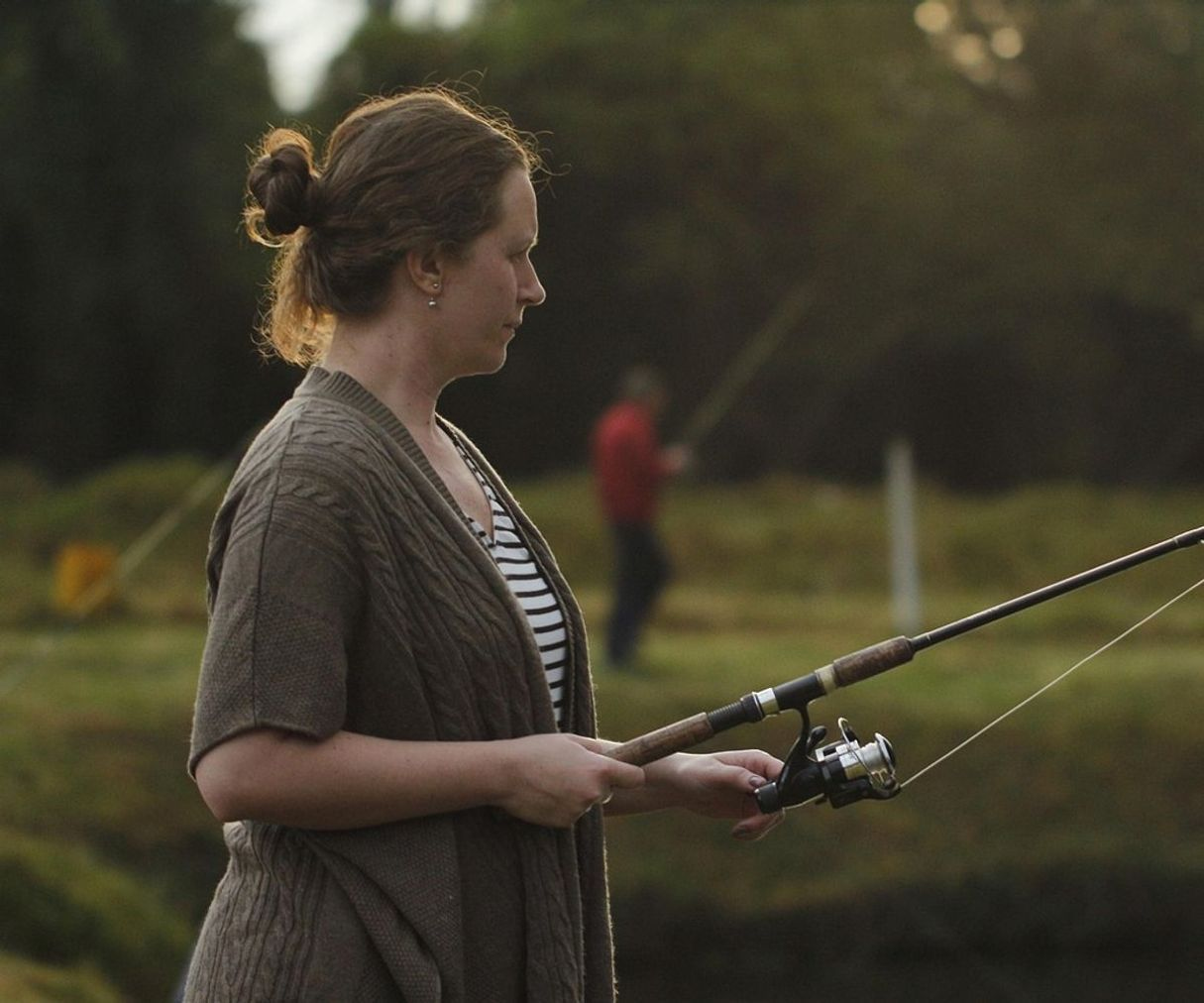 Hands tying a fishing knot with line and hook